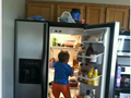 Funny baby climbs fridge